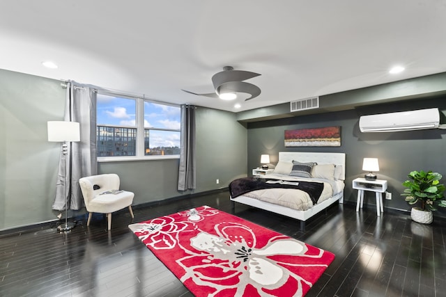 bedroom featuring wood-type flooring, a wall unit AC, and ceiling fan