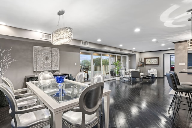 dining area featuring dark hardwood / wood-style floors and an inviting chandelier