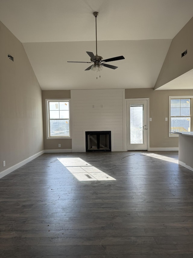 unfurnished living room with a fireplace, a healthy amount of sunlight, and lofted ceiling