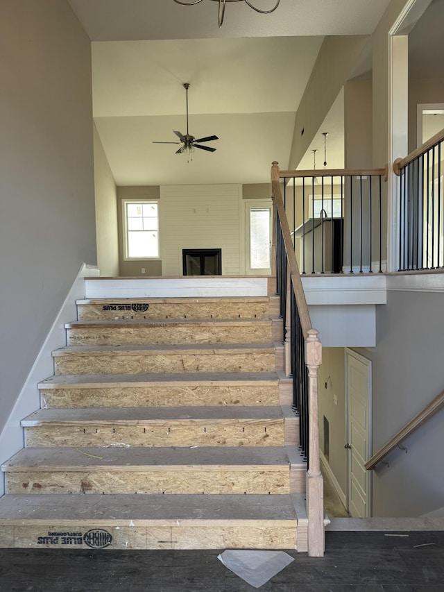 staircase featuring ceiling fan