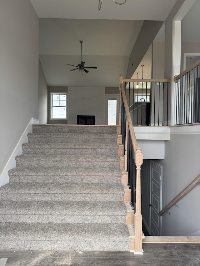 staircase with hardwood / wood-style floors and ceiling fan