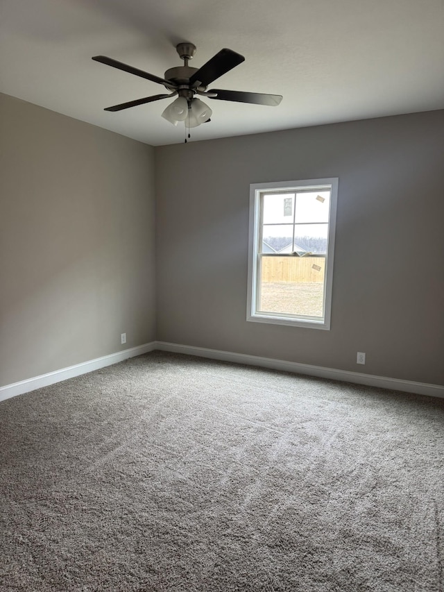 carpeted spare room featuring ceiling fan