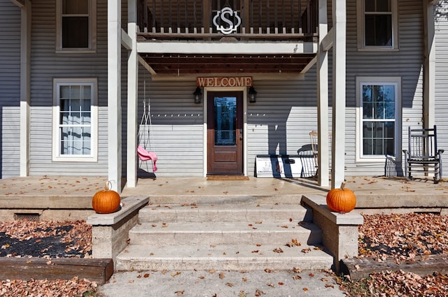 view of exterior entry with a balcony