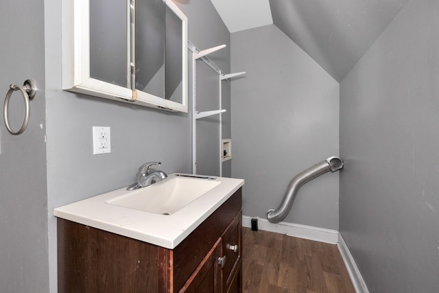 bathroom featuring vanity, hardwood / wood-style flooring, and vaulted ceiling