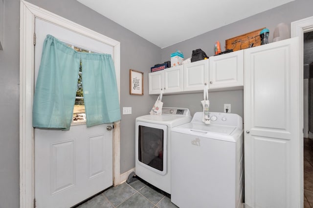 washroom featuring washer and dryer, cabinets, and dark tile patterned flooring