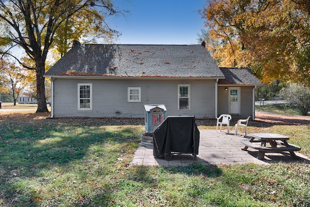 rear view of house with a patio and a lawn