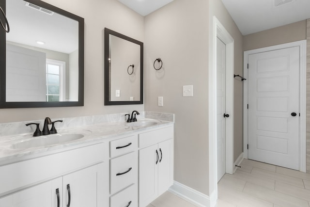 full bathroom with visible vents, a sink, baseboards, and double vanity