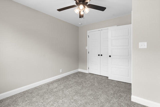 unfurnished bedroom featuring carpet floors, a closet, baseboards, and a ceiling fan