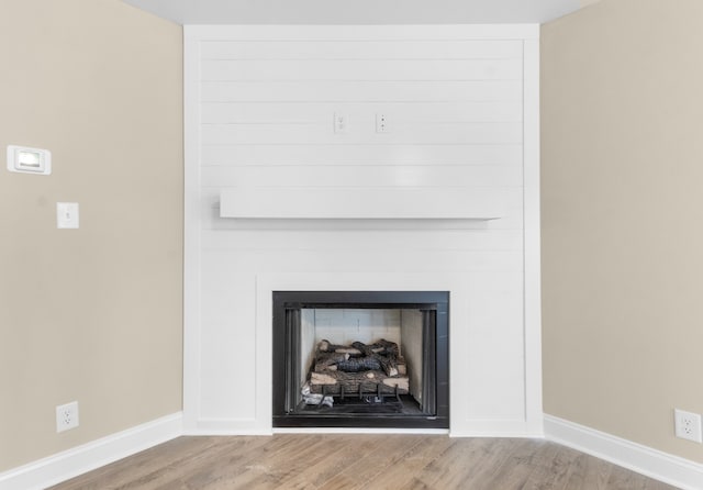 room details with a fireplace, wood finished floors, and baseboards