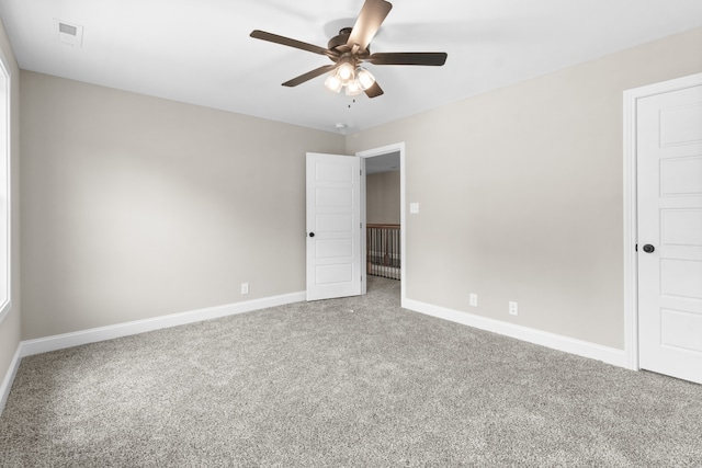 spare room featuring carpet, visible vents, ceiling fan, and baseboards