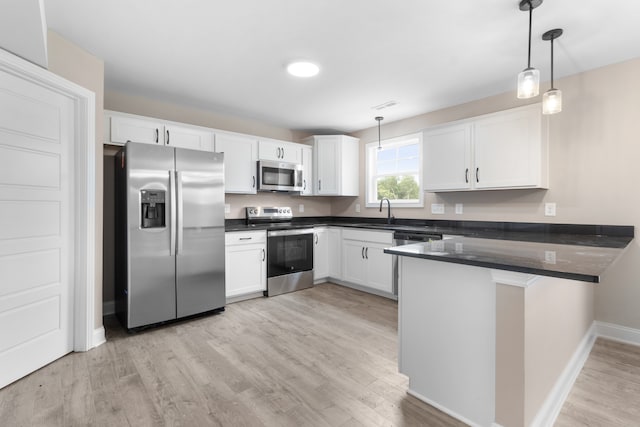 kitchen featuring white cabinetry, appliances with stainless steel finishes, kitchen peninsula, and hanging light fixtures