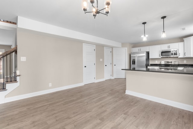 kitchen with dark countertops, light wood finished floors, baseboards, and stainless steel appliances