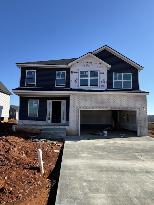 view of front of house featuring a garage, driveway, and brick siding