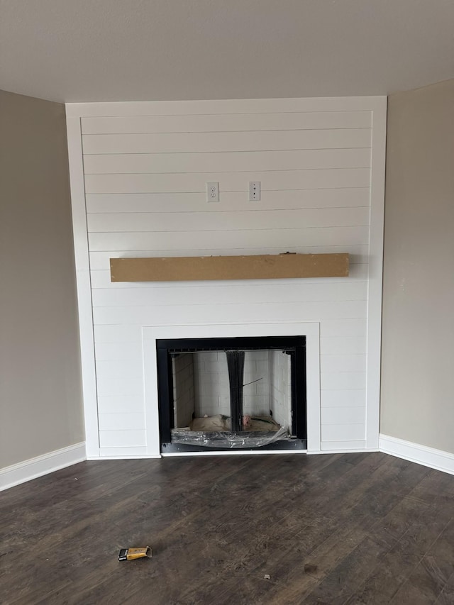 details featuring a fireplace, baseboards, and wood finished floors