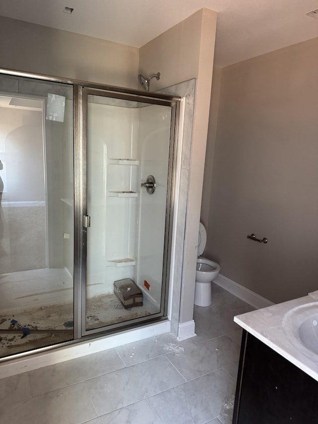 bathroom featuring vanity, tile patterned floors, a shower with door, and toilet