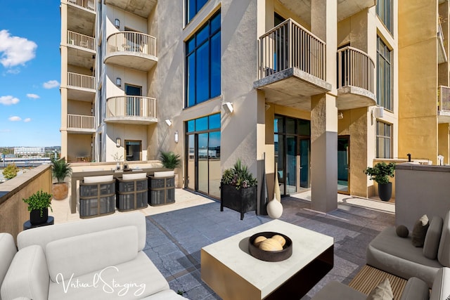 view of patio / terrace featuring an outdoor living space with a fire pit and a balcony