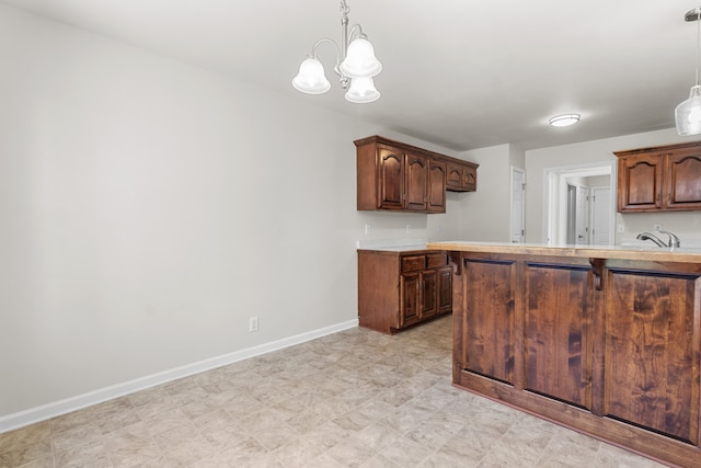 kitchen with decorative light fixtures, sink, and an inviting chandelier