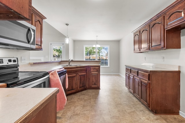 kitchen featuring appliances with stainless steel finishes, hanging light fixtures, a notable chandelier, and sink