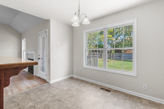 unfurnished dining area featuring light hardwood / wood-style flooring, an inviting chandelier, and lofted ceiling