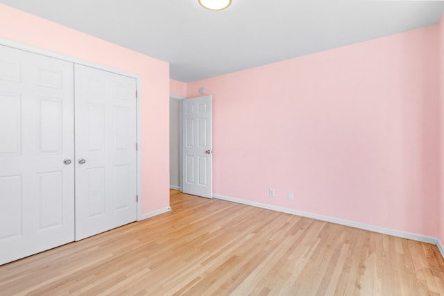 unfurnished bedroom with light hardwood / wood-style floors and a closet