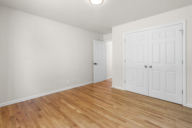 unfurnished bedroom with a closet and light hardwood / wood-style flooring