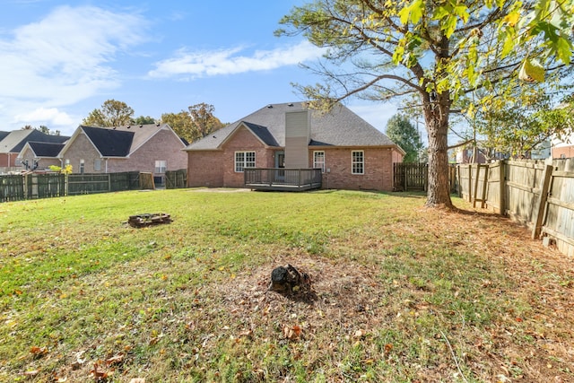 back of house featuring a lawn and a deck