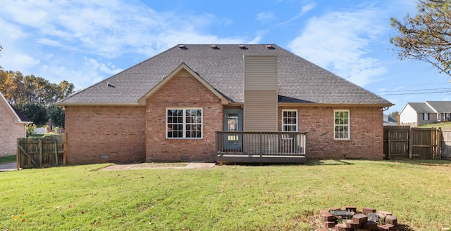 back of property featuring a lawn and a wooden deck