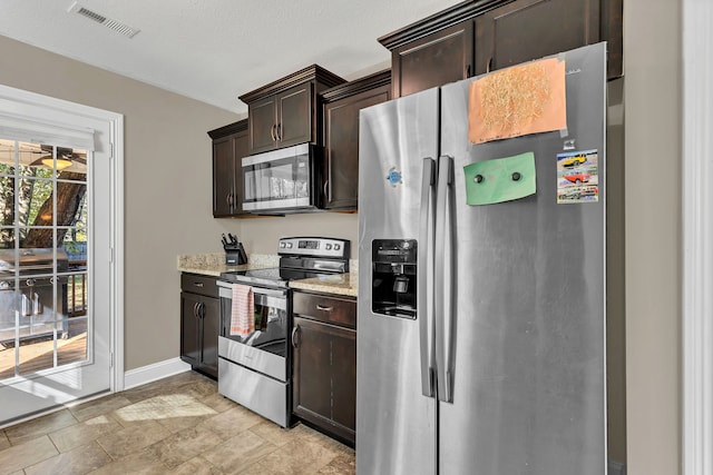 kitchen featuring light stone countertops, dark brown cabinetry, and stainless steel appliances