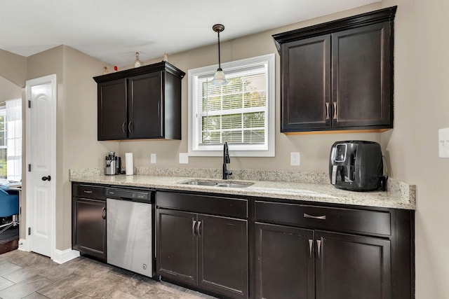 kitchen featuring dark brown cabinetry, sink, light stone countertops, decorative light fixtures, and stainless steel dishwasher