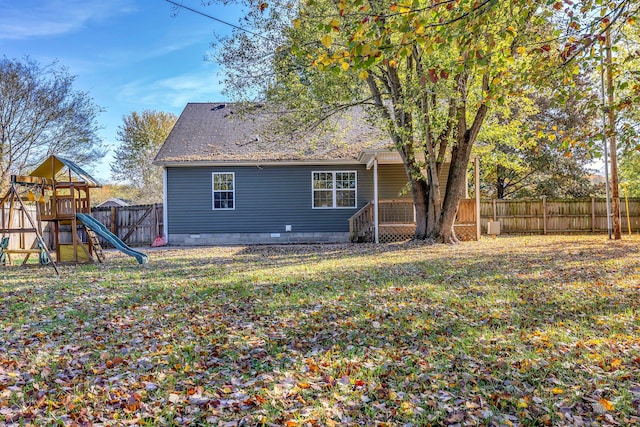 back of property with a playground and a yard