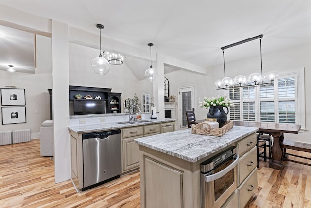 kitchen with stainless steel appliances, sink, a center island, pendant lighting, and light hardwood / wood-style floors