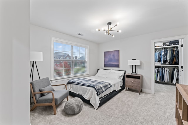 bedroom with a closet, a notable chandelier, and light colored carpet