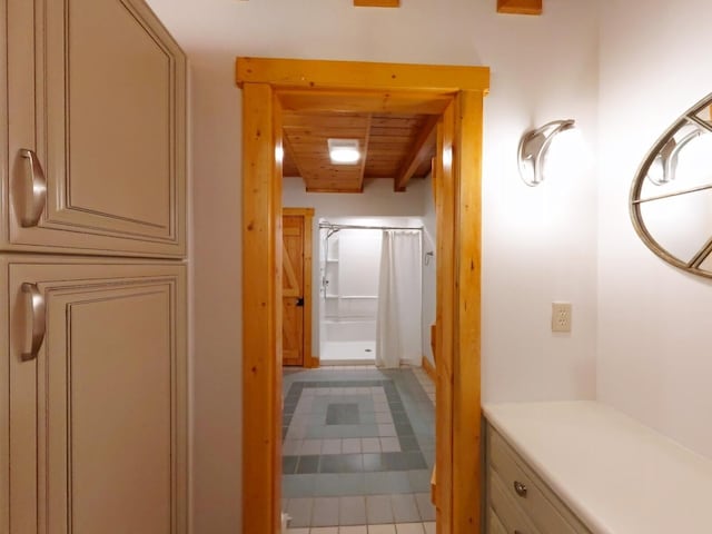 corridor with wooden ceiling, beamed ceiling, and tile patterned flooring