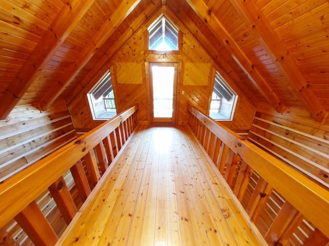 additional living space featuring vaulted ceiling with beams, wood walls, hardwood / wood-style flooring, and wooden ceiling