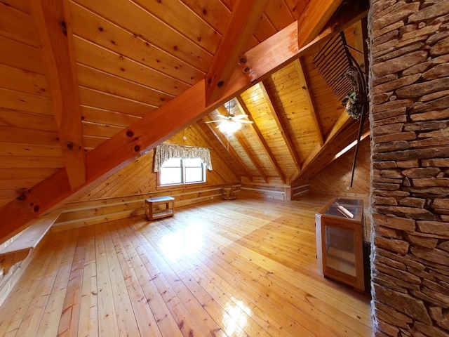 additional living space featuring light hardwood / wood-style floors, lofted ceiling with beams, wooden ceiling, and ceiling fan