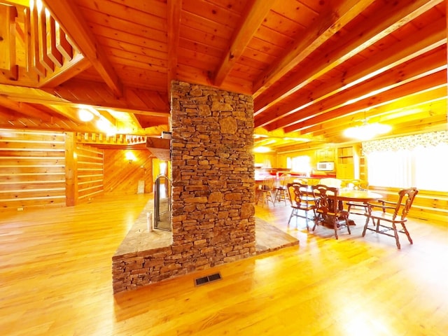 dining room with beam ceiling, hardwood / wood-style flooring, and wood ceiling