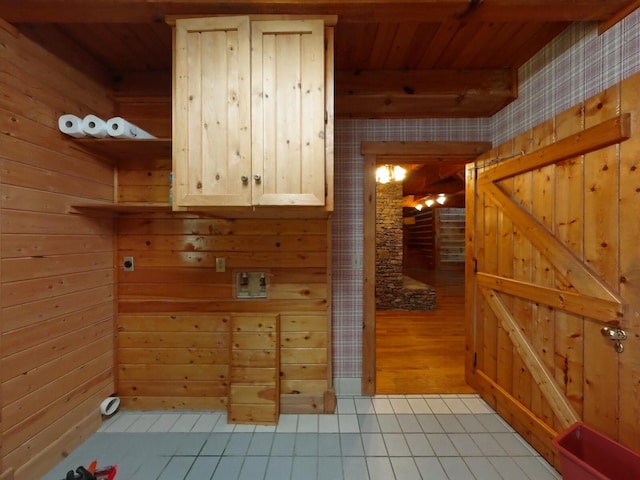 interior space with hookup for an electric dryer, wood walls, wooden ceiling, and light tile patterned floors