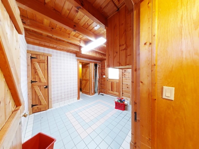 interior space featuring beamed ceiling, wooden walls, wooden ceiling, and tile patterned flooring