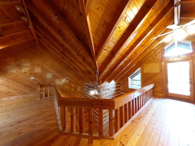 additional living space with vaulted ceiling with beams, wood ceiling, wood walls, and hardwood / wood-style flooring