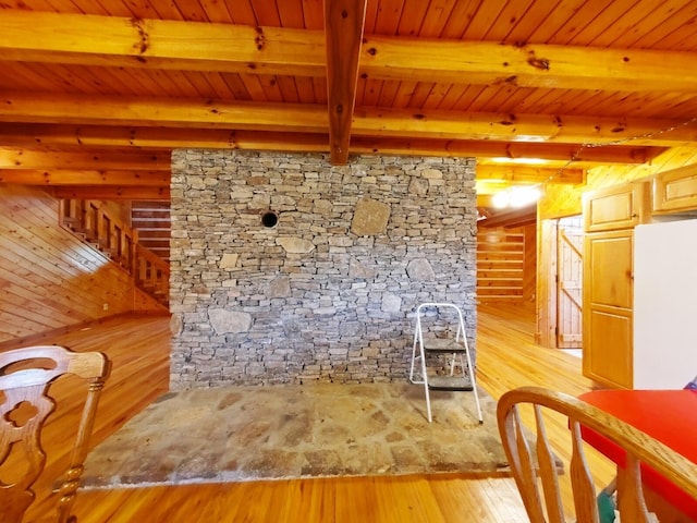 unfurnished living room featuring wood ceiling, beamed ceiling, and light hardwood / wood-style flooring