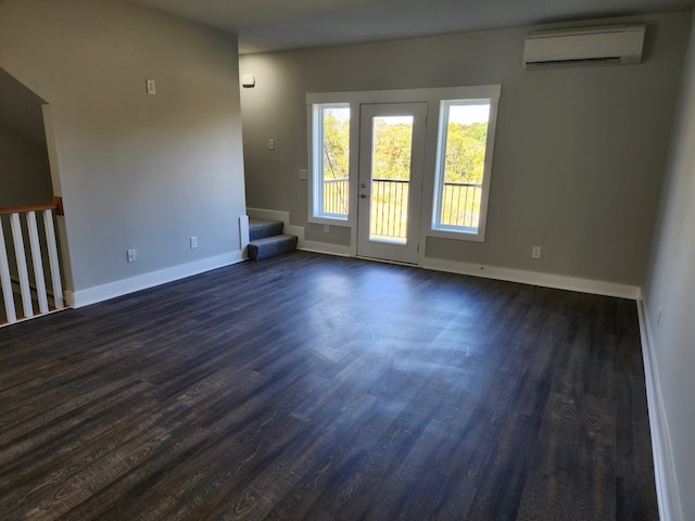 unfurnished room featuring a wall unit AC and dark hardwood / wood-style flooring