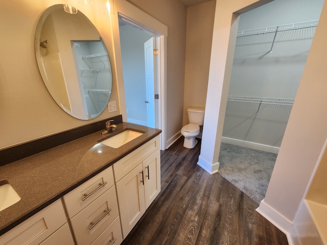 bathroom featuring toilet, hardwood / wood-style flooring, and vanity