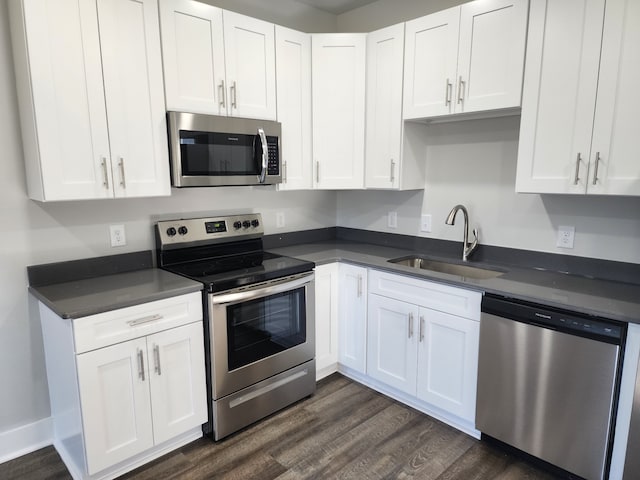 kitchen with white cabinetry, stainless steel appliances, sink, and dark hardwood / wood-style floors