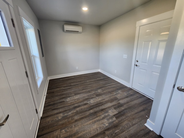 interior space featuring a wall unit AC and dark hardwood / wood-style flooring