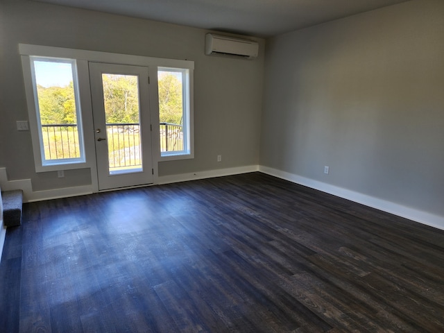 spare room with an AC wall unit and dark hardwood / wood-style floors