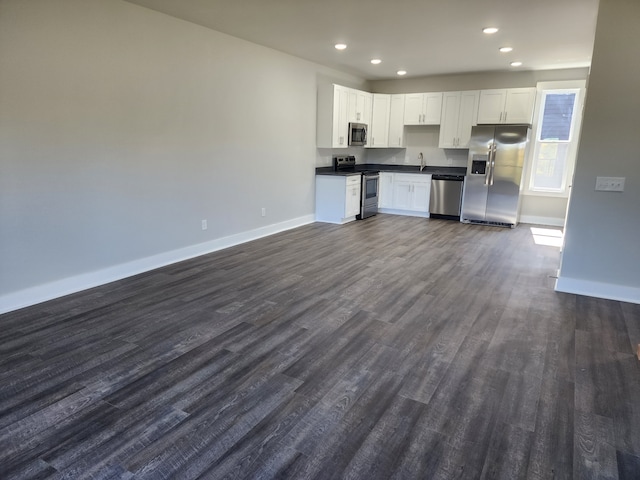 kitchen featuring appliances with stainless steel finishes, white cabinets, and dark wood-type flooring