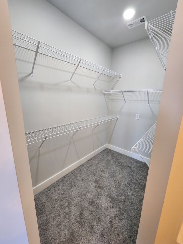 spacious closet featuring dark carpet