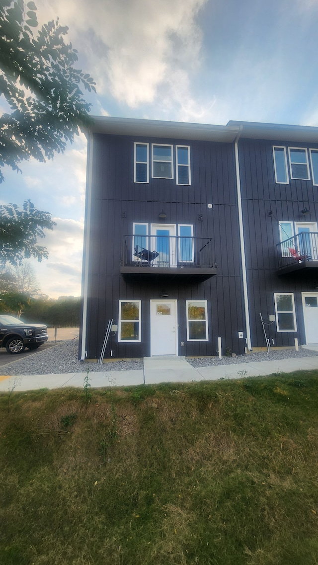 exterior space featuring a balcony and a yard