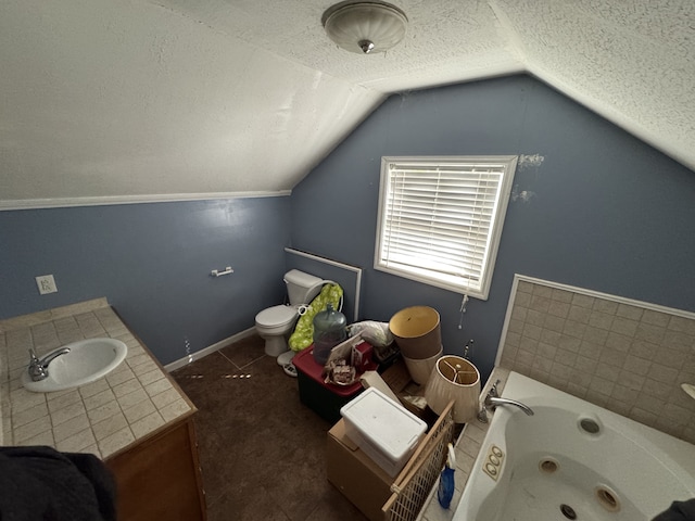 bathroom with toilet, a washtub, sink, vaulted ceiling, and a textured ceiling