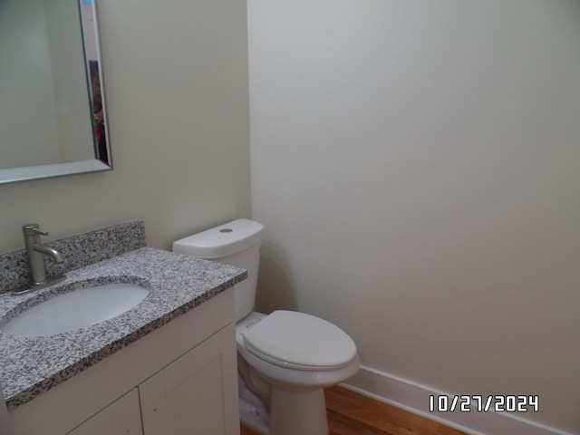 bathroom featuring vanity, hardwood / wood-style flooring, and toilet